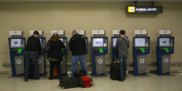 people standing in front of a row of machines