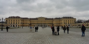 a group of people walking in front of a large building with Schönbrunn Palace in the background