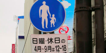 a blue sign with white silhouettes of people and a child on it