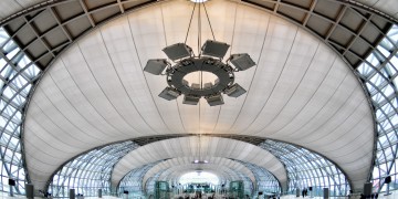 a large white building with glass walls and a circular ceiling