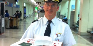 a man in uniform holding pizza boxes