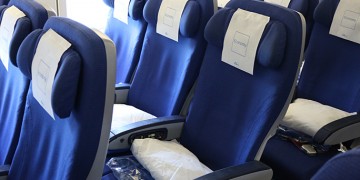 a row of blue chairs with white sheets on them