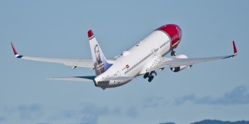 a white and red airplane flying in the sky