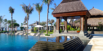 a pool with a gazebo and palm trees