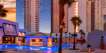 a pool with palm trees and a building in the background