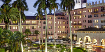 a building with palm trees and fountain