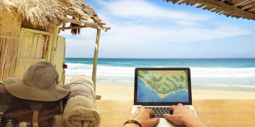 a person using a laptop on a beach