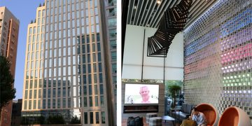 a man sitting in a chair next to a tall building