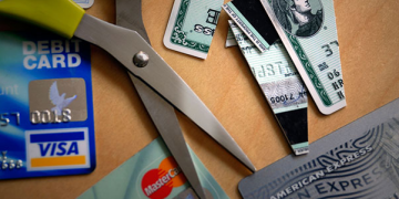 a pair of scissors next to credit cards