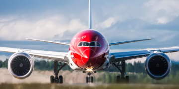 a red and white airplane on a runway