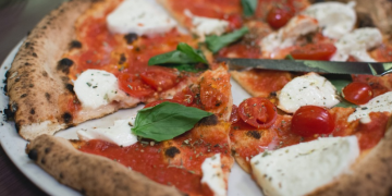 a pizza with tomatoes and cheese on a plate