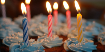 a close-up of cupcakes with lit candles