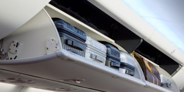 luggage on a shelf in an airplane