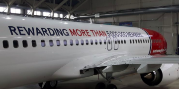 a white airplane with red and blue writing