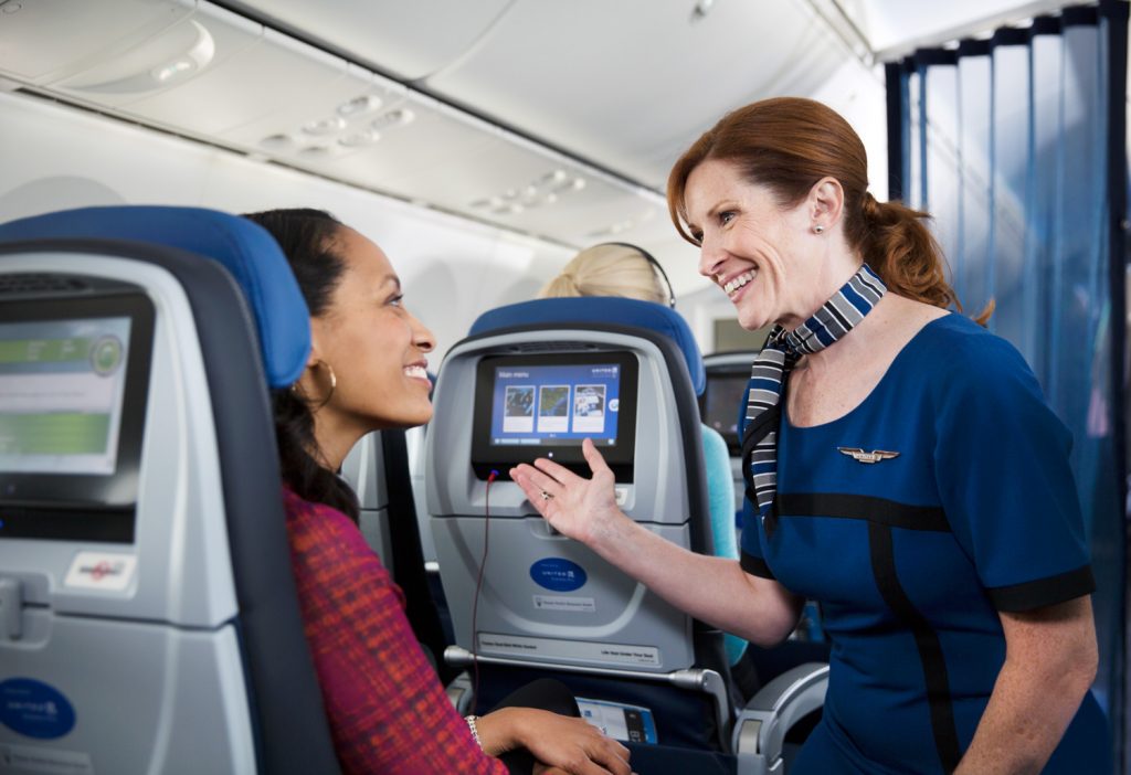 a woman talking to another woman on an airplane