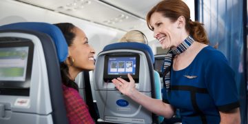 a woman talking to another woman on an airplane