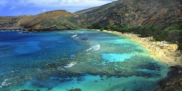 a beach with a rocky shore with Hanauma Bay in the background