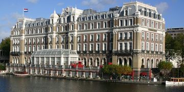 a large building with a river in the background