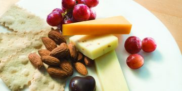 a plate of food with grapes and cheese