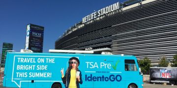 a blue bus parked in front of a stadium