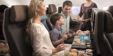 a family on an airplane eating food