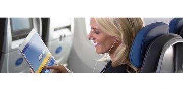 a woman using a tablet on an airplane