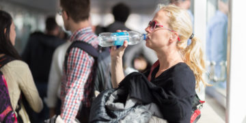 a woman drinking from a bottle