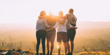 a group of people hugging on a hill