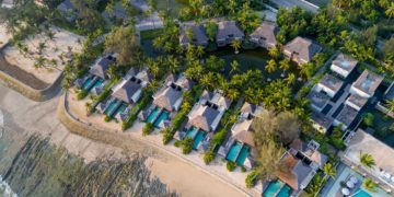 a aerial view of a resort with swimming pools and trees