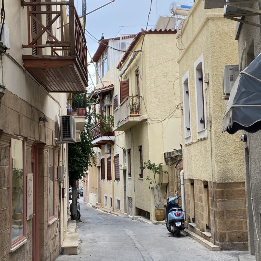 a narrow street with buildings and a scooter