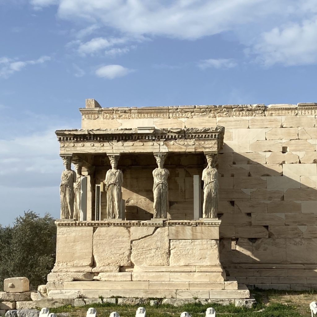 a stone building with statues on the porch