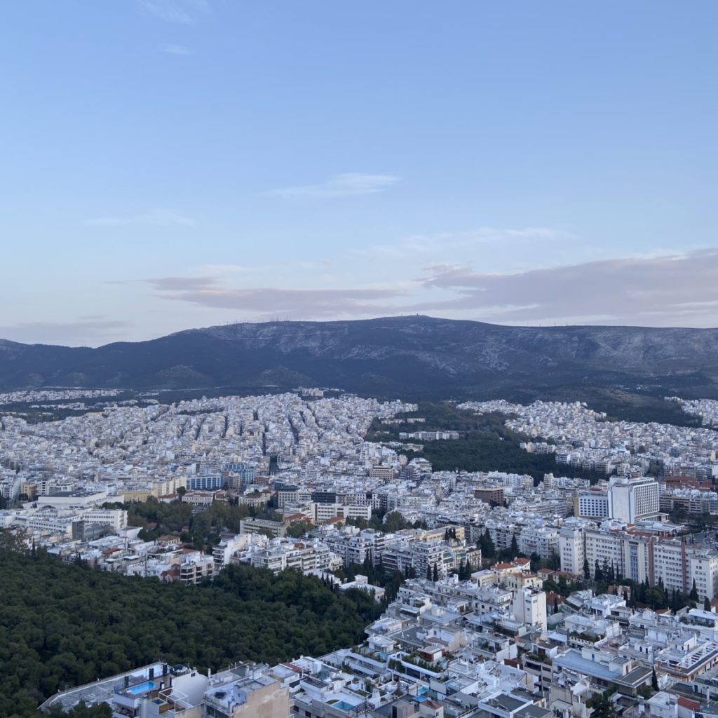 a city with trees and mountains in the background