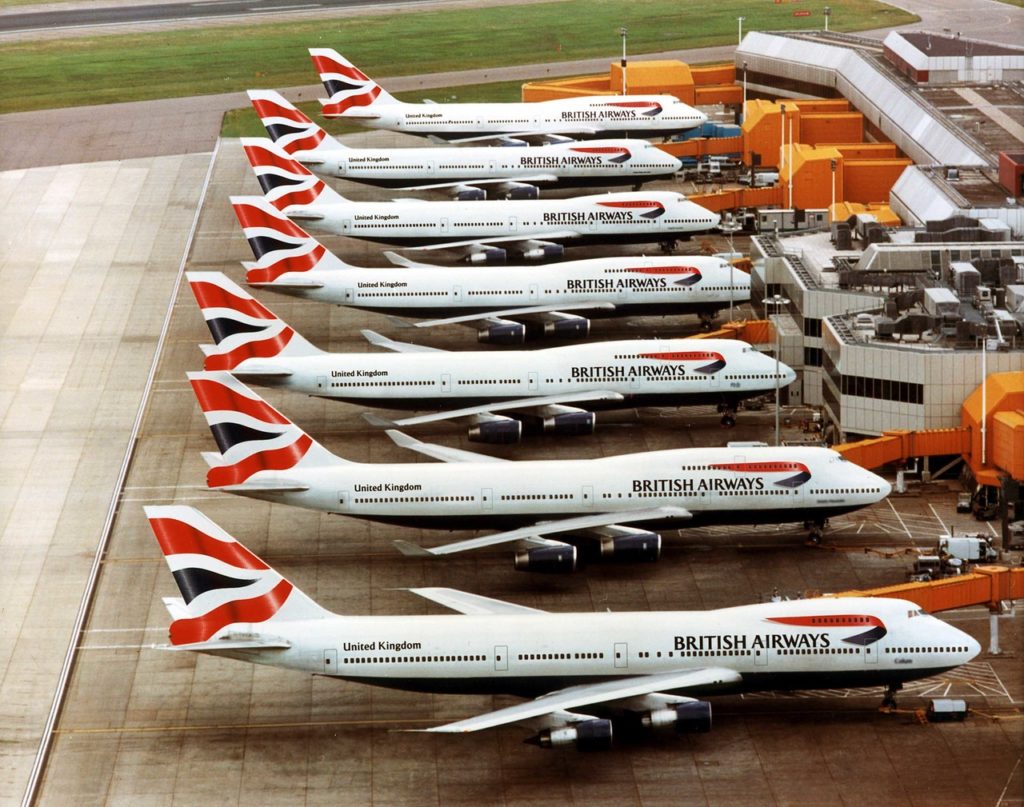 a group of airplanes parked at an airport