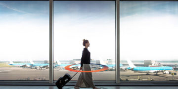 a woman walking with a suitcase in an airport