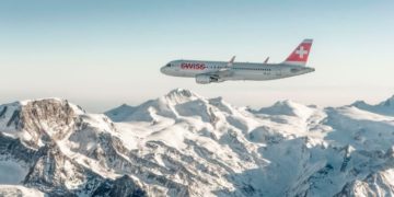 a plane flying over snowy mountains