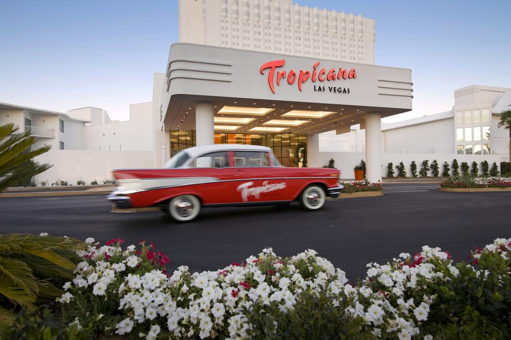 a red car in front of a hotel