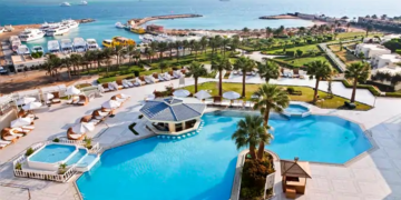 a swimming pool with palm trees and a body of water