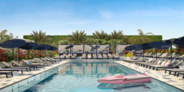 a pool with a pink raft and umbrellas