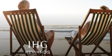 a couple of people sitting in chairs on a beach