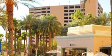 a swimming pool with palm trees and buildings