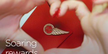 a close-up of hands making a heart with a logo