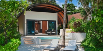 a pool and lounge chairs in a tropical setting