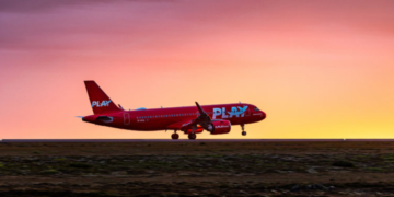 a red airplane on a runway