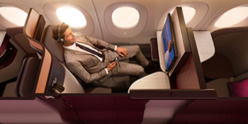 a man in a suit and tie sitting in a plane