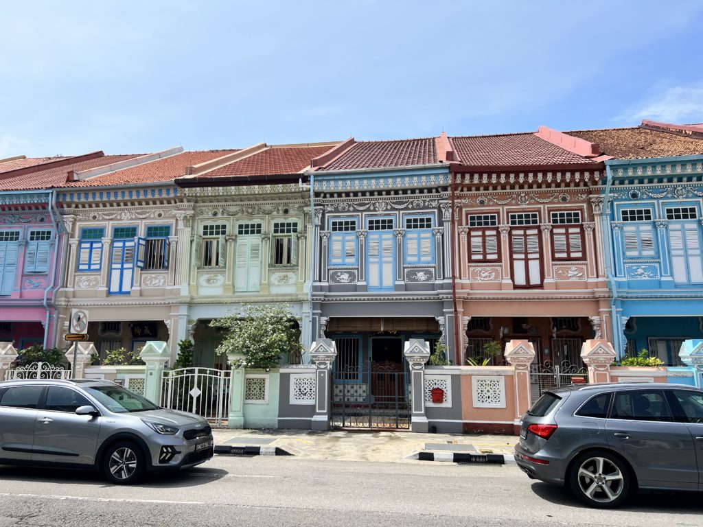 a row of colorful buildings with cars parked on the side of the road