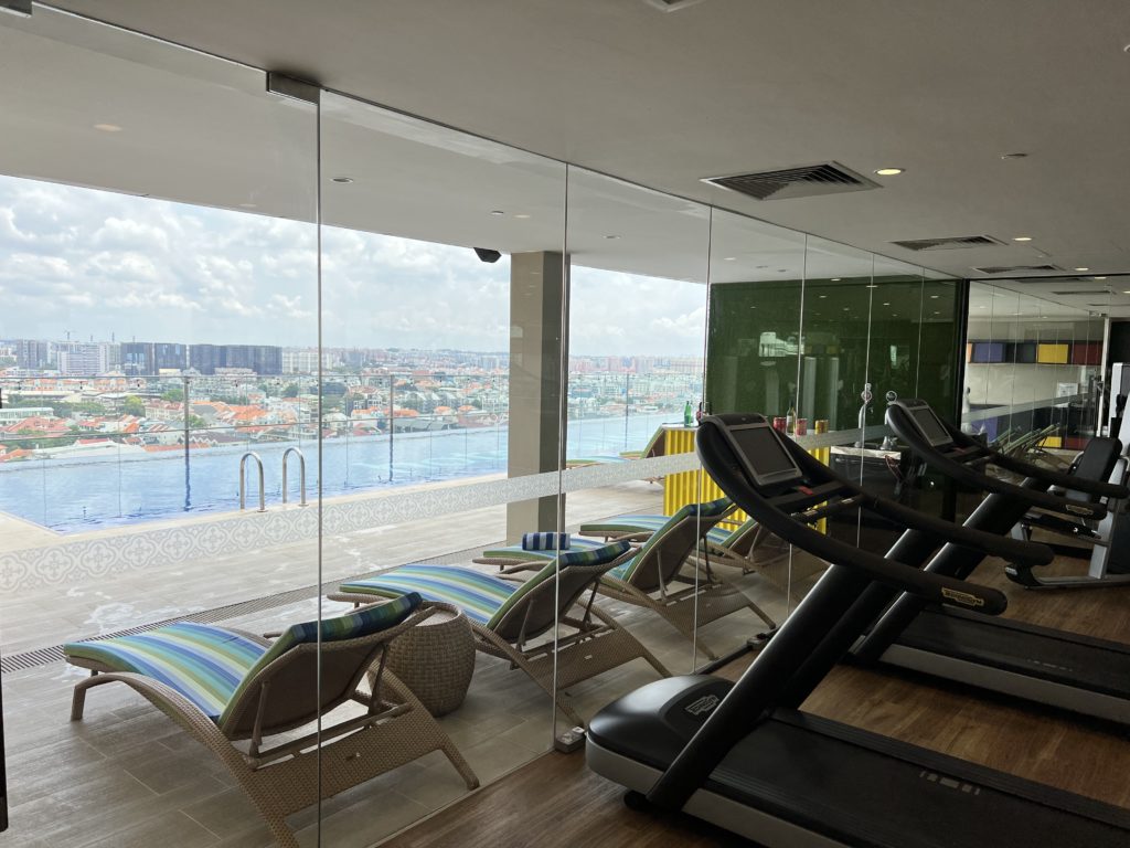 a room with exercise equipment and a pool