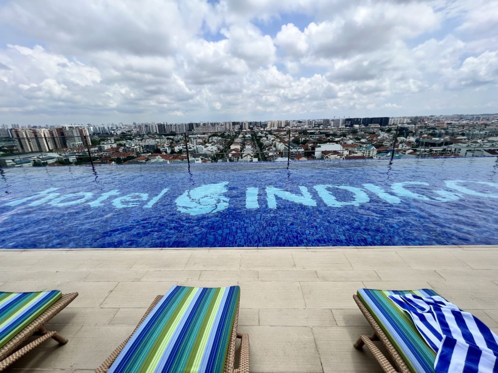 a pool with chairs and a city in the background