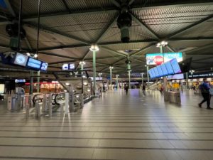 a large airport terminal with escalators and people walking