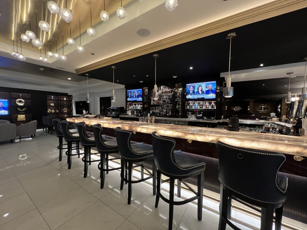 a bar with chairs and a row of lights