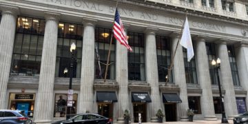 a building with flags and cars on the side